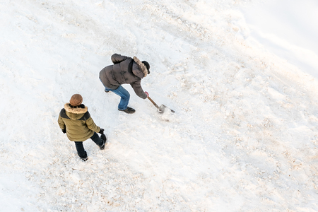 Two men cleans snow shovel, top viewの写真素材
