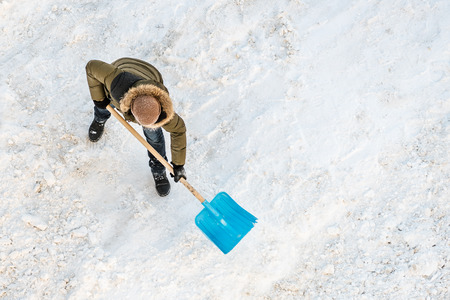 Man cleans snow shovel, top viewの写真素材