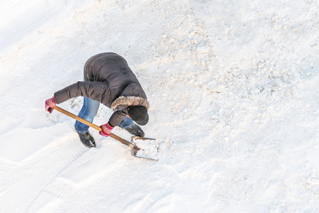 Man cleans snow shovel, top viewの写真素材
