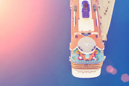 Part of a cruise ship with a helipad in the sunlight