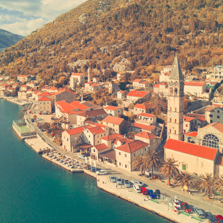 Top view of a beautiful city with red roofs near the sea. Toned