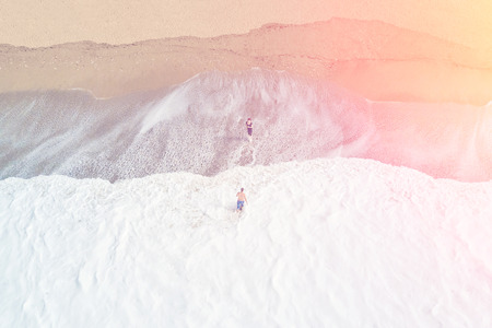 Man and woman on the beach in the sunlight, top view