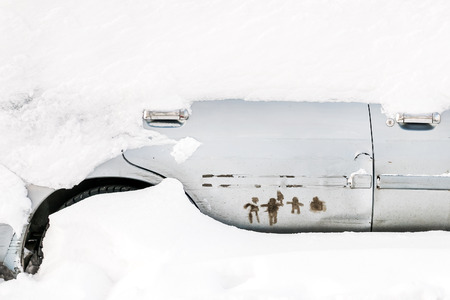 Parked car covered with snowの写真素材