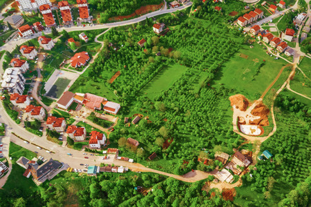 Top view of European resort town with orchards in the mountainsの写真素材