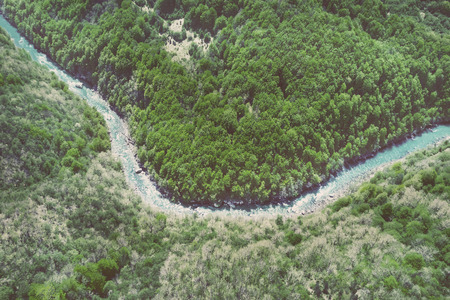 Top view of the river in the mountains surrounded by a green forestの写真素材
