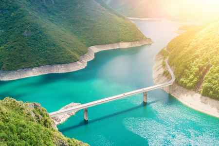 Automobile bridge across the lake in the mountains