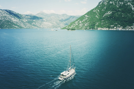 White yacht near the rocky shore