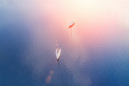 Top view of two sailboats floating in the sea on a sunny dayの写真素材