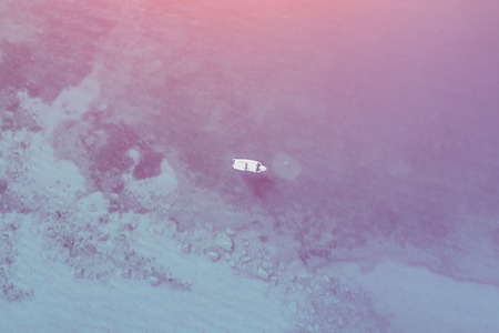 Top view of a white boat floating in the sea on a sunny day