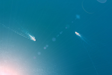 Top view of a two white boats sailing in the blue sea on a sunny dayの写真素材