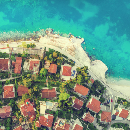 View from above to old cottages with tiled roofs near the seaの写真素材