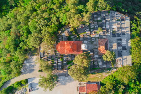 Top view of a church with a cemetery surrounded by green treesの写真素材