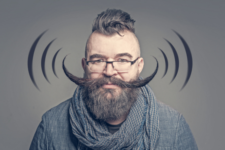 Adult bearded man with a very long mustache next to black wi-fi symbols. Tonedの写真素材