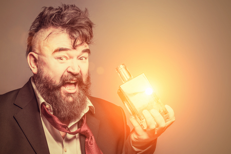 Adult bearded man in suit holding a glowing bottle of alcoholの写真素材