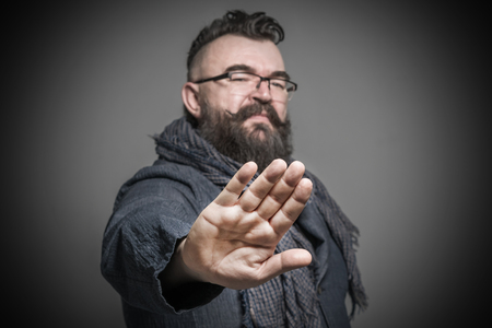 Adult bearded man with a mohawk hairstyle showing hands gesture stop. Tonedの写真素材