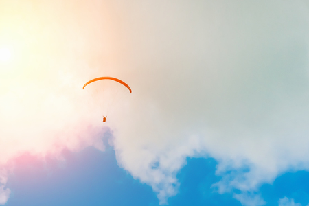 Silhouette of a paraglider in a sunny skyの写真素材