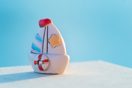 Blue small souvenir toy sailing ship on a blue backgroundの写真素材