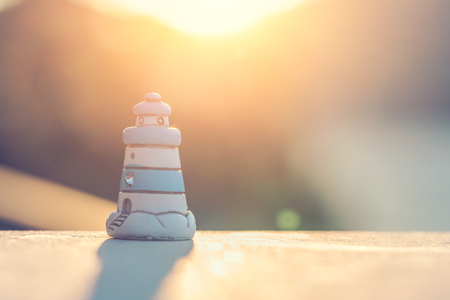 Small souvenir toy lighthouse  at sunsetの写真素材