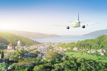 Airplane flying over resort European cityの写真素材