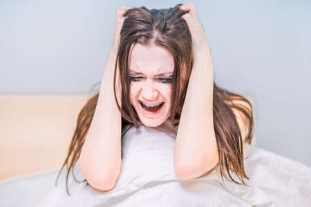 A beautiful woman reads a book with dim lights in her bedroom before going to bed. relaxation. Literature. self-developmentの写真素材