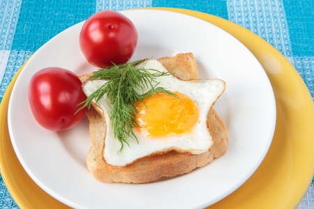 Toast with fried eggs and two tomatoesの写真素材