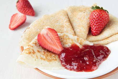 Wheat pancakes with strawberry jam and berriesの写真素材