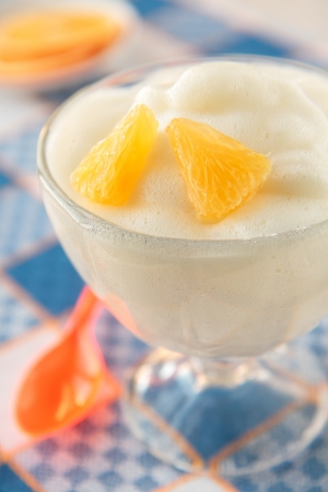 Orange mousse in a glass with orange slicesの写真素材