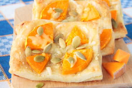 Puff pastry with pumpkin, garlic and cheese on boardの写真素材