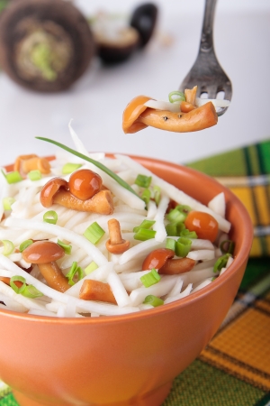 Radish salad with mushrooms and green onions in bowlの写真素材