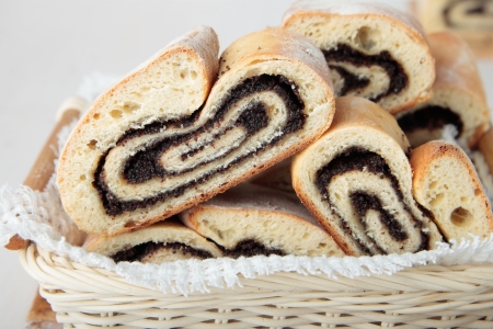 Bread rolls with poppy seeds in a small basketの写真素材