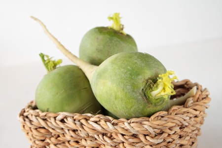 Square basket with three green radish root vegetablesの写真素材