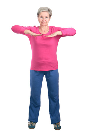 Cheerful elderly woman doing gymnastic exercises vigorouslyの写真素材
