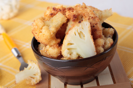 Cauliflower fried in eggs and bread crumbs in a ceramic bowlの写真素材