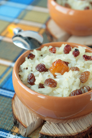 Sweet casserole of rice and raisins in two bowlsの写真素材