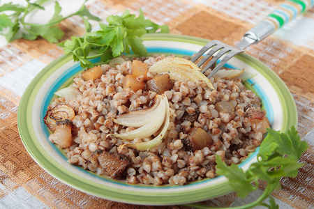 Buckwheat porridge with fried bacon and onions on plateの写真素材