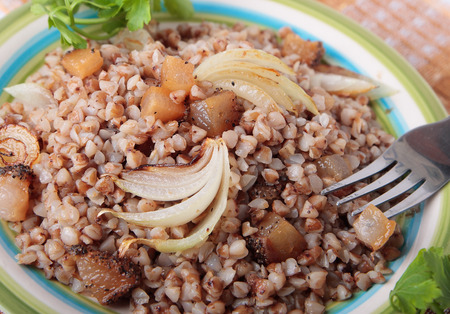 Buckwheat porridge with fried bacon and onions on plateの写真素材