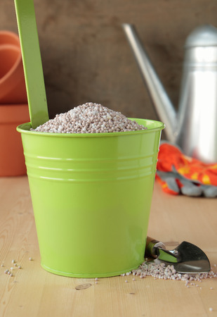 Green bucket with a fertilizer for the gardenの写真素材