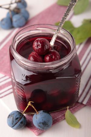 Marinated berries of blackthorn in a square glass jarの写真素材
