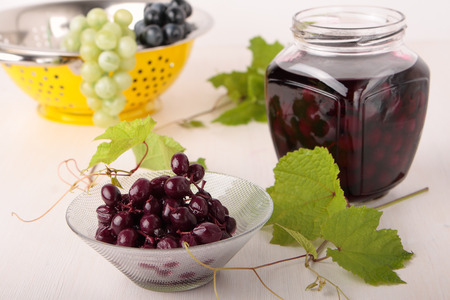 Pickled red grapes in a glass bowl and jarの写真素材