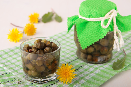 Pickled flower buds of dandelions in a glass  jarの写真素材