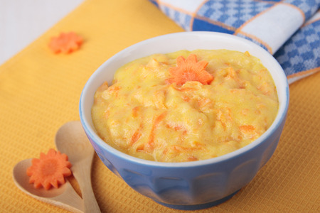 Dairy semolina with carrots in a blue ceramic bowlの写真素材