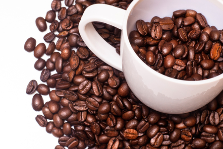 Closeup of white coffee cup full of coffee beansの写真素材