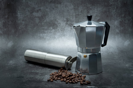 Moka pot with coffee beans on dark gray background.の写真素材