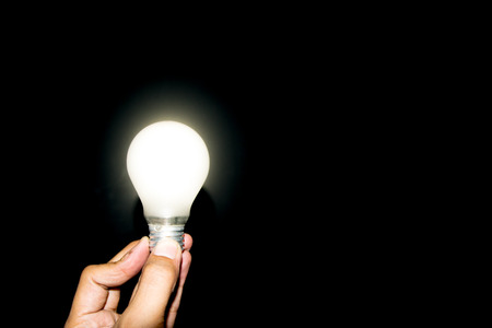 Glowing light bulb on hand on white background.の写真素材