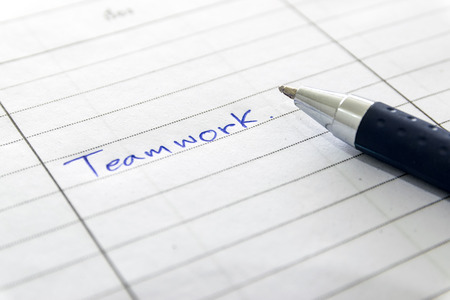 Blue ballpen writed teamwork on the book.の写真素材