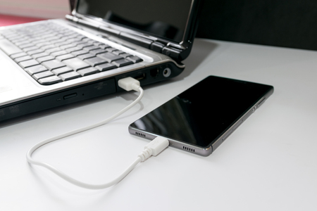 Connec smartphone to notebook by USB cable.の写真素材