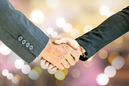 Business men and women shaking hands with each other to work together.の写真素材