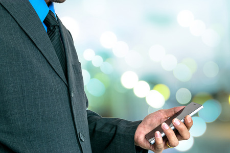 Young businessman using a smart phone to run his business.の写真素材