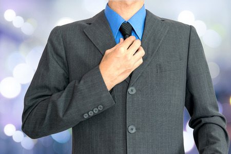 Young businessman Wearing a blue shirt, black tie and then covered with a gray suit.の写真素材