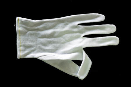 White cotton gloves isolated on black background.の写真素材